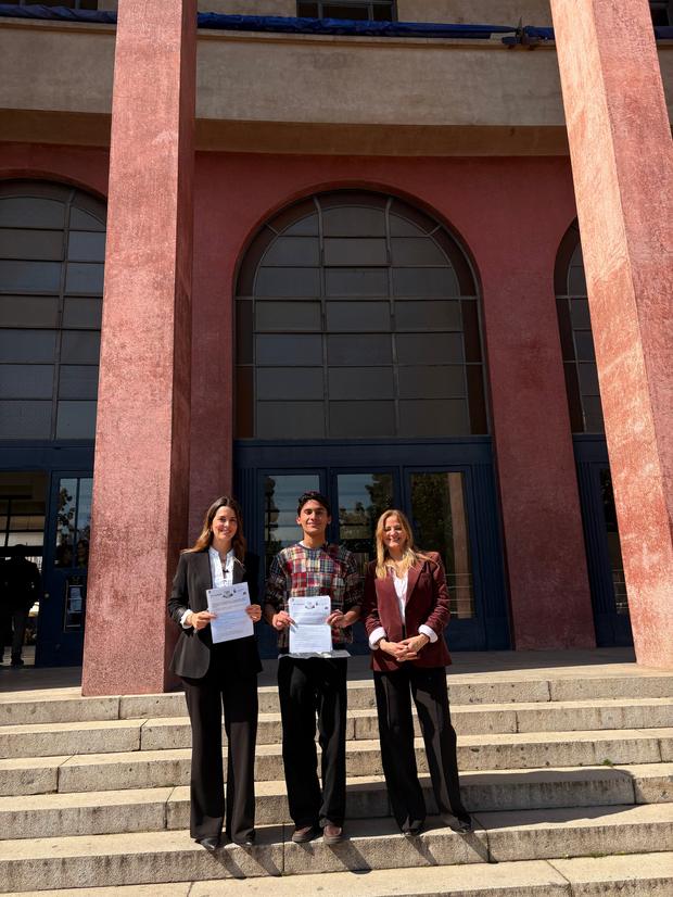 Estudiantes con certificados en la escalinata de su facultad